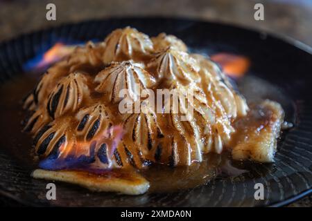 Banana Foster serviert Tischseite mit Marshmallow Flusen, die mit einer Flamme als Teil der Präsentation gekocht werden. Stockfoto