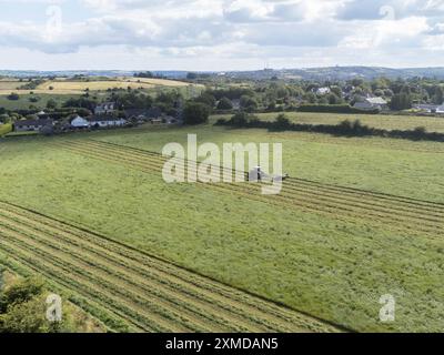 Cork, Irland. Juli 2024. DC 27-7-24 Landwirte nutzen das gute Wetter am Wochenende, Cork, Irland. Mit der Wettervorhersage für die kommende Woche nutzen Landwirte im ganzen Land die Gelegenheit, ihre Arbeit zu erledigen. Auf dem Bild ist ein Bauer in Killcully, Kork schneidet seine Silage. Viele Bauern arbeiten die Nacht durch, während das Wetter gut bleibt, um sicherzustellen, dass sie alle Silage schneiden und sammeln. Quelle: Damian Coleman/Alamy Live News Stockfoto