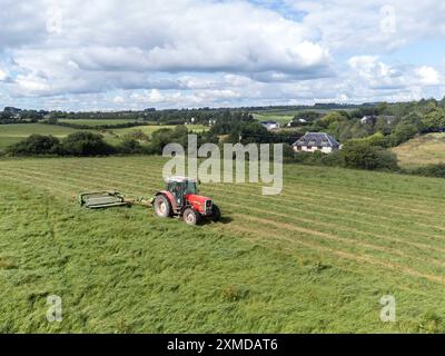 Cork, Irland. Juli 2024. DC 27-7-24 Landwirte nutzen das gute Wetter am Wochenende, Cork, Irland. Mit der Wettervorhersage für die kommende Woche nutzen Landwirte im ganzen Land die Gelegenheit, ihre Arbeit zu erledigen. Auf dem Bild ist ein Bauer in Killcully, Kork schneidet seine Silage. Viele Bauern arbeiten die Nacht durch, während das Wetter gut bleibt, um sicherzustellen, dass sie alle Silage schneiden und sammeln. Quelle: Damian Coleman/Alamy Live News Stockfoto