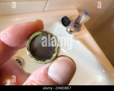 Verkalkter, verstopfter Wasserhahnbelüfter, Kalkrückstände verstopfen das Sieb des Wasserhahnbelüfters Stockfoto