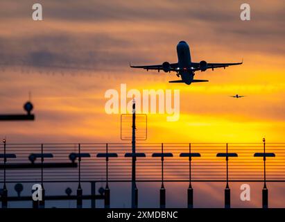 Start- und Landebahnbeleuchtung, Anflughilfen, am Flughafen Düsseldorf, Sonnenuntergang, Flugzeuge, die auf die südliche Hauptbahn starten und sich nähern, 05R/23L Stockfoto