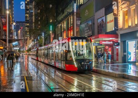 George Street Straßenbahnen im Regen mit Reflexionen in Sydney, Australien, NSW. Stockfoto