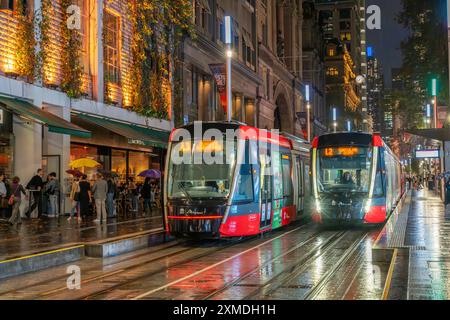 George Street Straßenbahnen im Regen mit Reflexionen in Sydney, Australien, NSW. Stockfoto