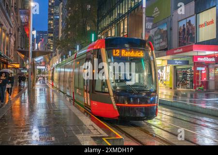 George Street Straßenbahnen im Regen mit Reflexionen in Sydney, Australien, NSW. Stockfoto