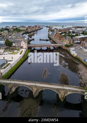 Fluss esk fließt durch musselburgh mit der alten Brücke und der neuen Brücke an einem bewölkten Tag Stockfoto