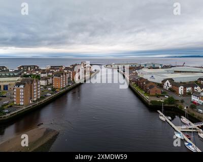 Aus der Vogelperspektive auf den Fluss clyde, der in Richtung Meer fließt und Industriegebäude von Wohngebäuden trennt, an einem bewölkten Tag in schottland Stockfoto