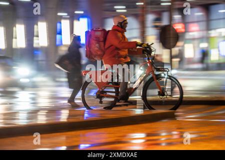 Straße am Hauptbahnhof, Lieferando Kurier, Radfahrer, regnerisches Wetter, Stadtzentrum, abends Essen, Nordrhein-Westfalen, Deutschland Stockfoto