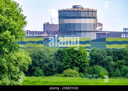 Das Stahlwerk ThyssenKrupp in Duisburg-Beeckerwerth, Radfahrer am Rheindeich, grüne Rheinwiesen Landschaft, Nordrhein-Westfalen, Deutschland Stockfoto