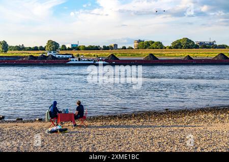 Der Rhein bei Duisburg-Bärl, Mann und Frau beim Picknick am Rheinstrand, bei Ebbe, auf der anderen Seite des Rheins ThyssenKrupp Steel Stockfoto