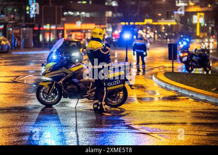 Polizist mit Motorrad, bei regnerischem Wetter, blockiert eine Straße, Polizeimotorrad mit blauem Licht Stockfoto