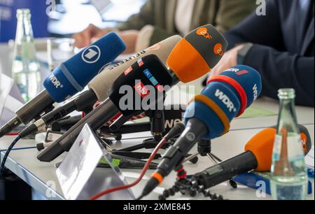 Mikrofone verschiedener Radio- und Fernsehsender stehen bei einer Pressekonferenz auf dem Tisch Stockfoto