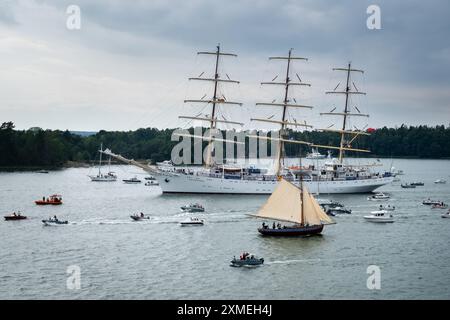 MARIEHAMN, Åland, FINNLAND - 27. JULI 2024: Das polnische Großschiff dar Mlodziezy setzt die Segel. Die 57 großen Schiffe verlassen Mariehman nach Stettin in Polen und fahren in Begleitung von über 500 Sportbooten in die Ostsee. Die Åland-Etappe des Tall Ships Race 2024 in Mariehamn, Åland, Finnland. Foto: Rob Watkins/Alamy Live News. INFO: Das Tall Ships Race ist eine jährliche Segelveranstaltung mit historischen und modernen Großschiffen. Es fördert internationale Freundschaft und Jugendausbildung und zieht Teilnehmer und Zuschauer weltweit an, um maritimes Erbe und traditionelles Segeln zu feiern. Gutschrift: R Stockfoto