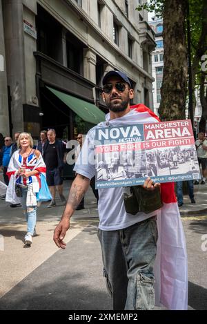 Demonstration mit Plakat, das den Terroranschlag des Nova Festivals mit dem Terroranschlag der Manchester Arena gleichsetzt, Tommy Robinson, märz, London, Großbritannien, 27/07/2024 Stockfoto