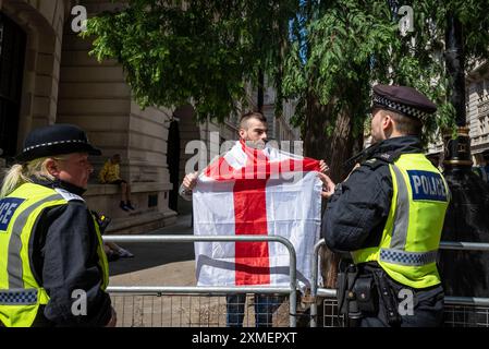 Ein Demonstrator mit englischer Flagge unterstützt Tommy robinson march und die Polizei, London, UK, 27/07/2024 Stockfoto