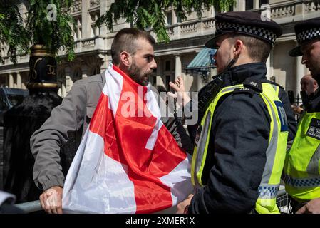 Ein Demonstrator mit englischer Flagge unterstützt Tommy robinson march und die Polizei, London, UK, 27/07/2024 Stockfoto