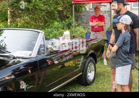 Hilton Beach, Ontario, Kanada - 27. Juli 2024: Ford Mustang Cabrio 1966 schwarz auf der Classic Car Show. A&W-Fenster im Retro-Stil. Stockfoto