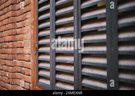 Plakat mit Metalljalousien an der Wand eines alten Backsteinhauses, Plakat für Werbekonzept über Bau und Wiederaufbau von Häusern Stockfoto