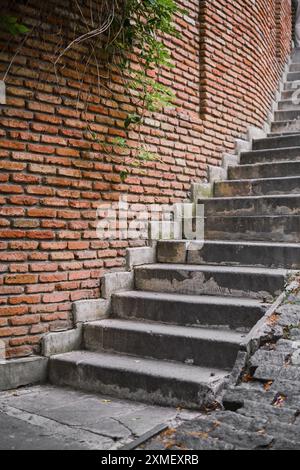Treppen durch eine Backsteinmauer in einer steilen Straße in der Altstadt, Zeit für Reisen und Erhaltung des Kulturerbes Stockfoto
