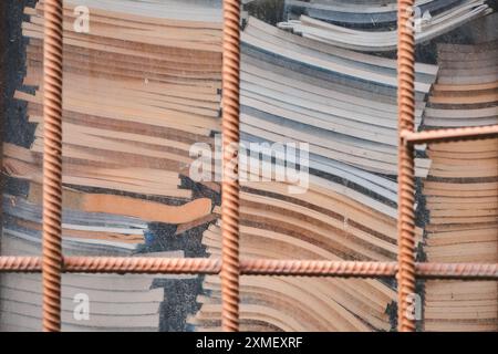 Alte Bücher und Zeitschriften hinter Gittern am Fenster, Konzept zum Recycling von Altpapier Stockfoto