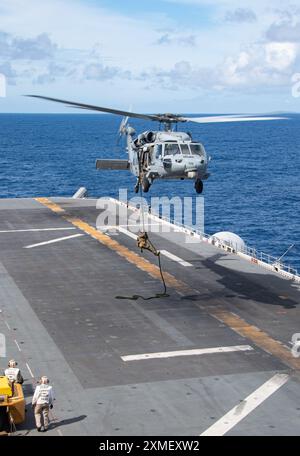 240725-N-PV363-1083 PHILIPPINISCHE SEE (25. Juli 2024) Marines der 31st Marine Expeditionary Unit Schnellseil von einem MH-60S Sea Hawk Hubschrauber von der Helicopter Sea Combat Squadron (HSC) 25 zum Flugdeck des vorgelagerten amphibischen Angriffsschiffs USS America (LHA 6) während eines Besuchs an Bord, Such- und Beschlagnahmungsübung (VBSS) bei Routineeinsätzen in der Philippinischen See, 25. Juli. America, Leitschiff der America Amphibious Ready Group, ist im Einsatzgebiet der 7. US-Flotte im Einsatz. Die 7. US-Flotte ist die größte nach vorne ausgerichtete nummerierte Flotte der US Navy und Routin Stockfoto