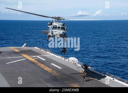 240725-N-PV363-1187 PHILIPPINISCHE SEE (25. Juli 2024) Marines der 31st Marine Expeditionary Unit Schnellseil von einem MH-60S Sea Hawk Hubschrauber von der Helicopter Sea Combat Squadron (HSC) 25 zum Flugdeck des vorgelagerten amphibischen Angriffsschiffs USS America (LHA 6) während eines Besuchs an Bord, Such- und Beschlagnahmungsübung (VBSS) bei Routineeinsätzen in der Philippinischen See, 25. Juli. America, Leitschiff der America Amphibious Ready Group, ist im Einsatzgebiet der 7. US-Flotte im Einsatz. Die 7. US-Flotte ist die größte nach vorne ausgerichtete nummerierte Flotte der US Navy und Routin Stockfoto