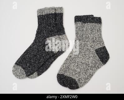 Dieses Bild zeigt zwei Paar Stricksocken aus Wolle in zwei Grautönen. Die Socken sind dick und bequem und halten sich ideal bei kaltem Wetter warm. Ein Stockfoto