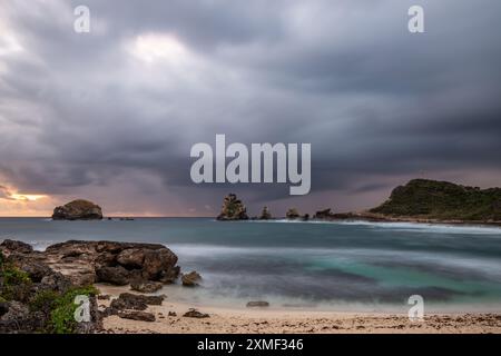 Stony Coast mit Sharp Rock Formationen in A Bay in the Sea. Regnerischer Sonnenaufgang, Dramatische Atmosphäre. Pointes Des Colibris Auf Grande Terre, Guadeloupe, Fren Stockfoto