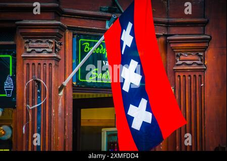 In Amsterdam hängt eine rote, weiße und blaue Flagge an einer Holztür. Es könnte eine patriotische Darstellung oder ein Begrüßungssymbol sein, aber es könnte auch nur ein c sein Stockfoto