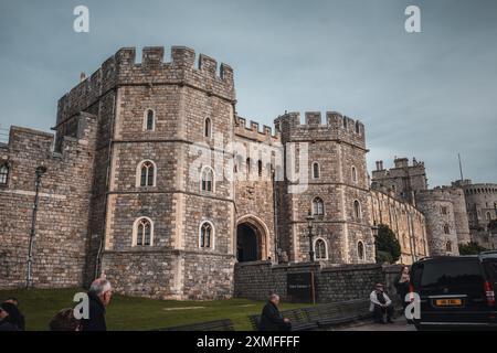 Windor Castle, Großbritannien - 16. Oktober 2023 : die Fassade eines alten Schlosses mit einem dunklen, bewölkten Himmel darüber. Stockfoto