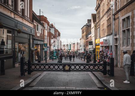 Windor Castle, Großbritannien - 16. Oktober 2023 : Eine kopfsteingepflasterte Straße in einer historischen britischen Stadt mit Geschäften an beiden Seiten und Fußgängern. Stockfoto