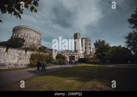 Windor Castle, Großbritannien - 16. Oktober 2023 : Ein Blick auf Windsor Castle mit einer Gruppe von Menschen, die vor den massiven Steinmauern und Türmen spazieren. Stockfoto