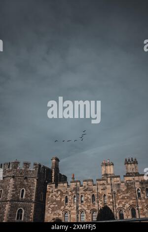 Windor Castle, Großbritannien - 16. Oktober 2023 : Ein grauer, bedeckter Himmel über einem Steingebäude mit Schornsteinen und Bogenfenstern. Stockfoto