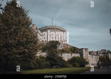 Windor Castle, Großbritannien - 16. Oktober 2023 : Eine große Steinburg mit einem hohen runden Turm vor einem bewölkten Himmel. Stockfoto