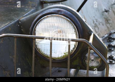 Ein Fernlicht, das bei alten gepanzerten Fahrzeugen durch einen speziellen Kühlergrill geschützt wird. Stockfoto