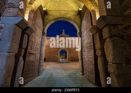 Blick durch das Stadttor Puerta Nueva de Bisagra (Neues Bisagra Tor, neue Scharniertür) in Toledo, Spanien. Das antike mittelalterliche Stadttor wird in der Abenddämmerung beleuchtet Stockfoto