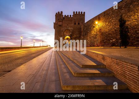 Toledo Panoramablick auf die Landschaft mit erleuchteter Puerta del Sol (Sonnentor), einem antiken mittelalterlichen Stadttor in Toledo, Spanien bei Sonnenaufgang ohne Menschen. Stockfoto