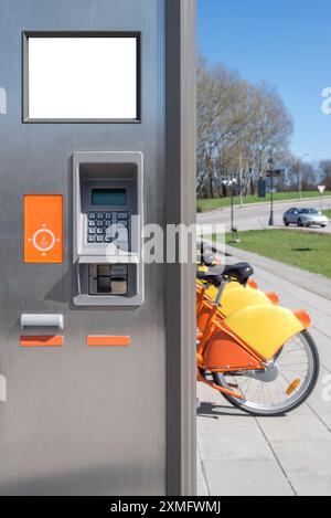 Mockup Des Ticketautomaten Für Den Städtischen Fahrradverleih Vor Orange Bicycle. Elektronische Zahlungsanzeige Im Freien Stockfoto