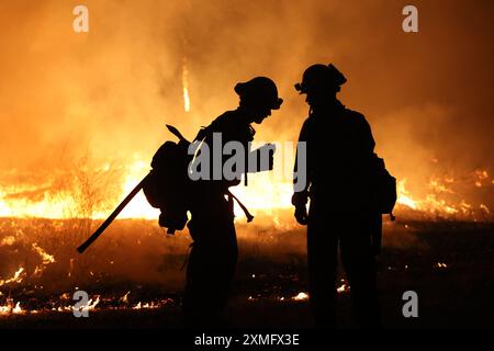 Das Foto zeigt Feuerwehrmänner, die am 26. Juli 2024 in Kalifornien, USA, gegen To Flames kämpften. Kaliforniens größtes aktives Feuer explodierte am Freitagabend, wuchs rasch unter knochentrockenen Brennstoffen an und bedrohte Tausende von Häusern, als sich die Feuerwehrleute um die Gefahr bemühten. Die Intensität und schnelle Ausbreitung des Parkfeuers veranlassten die Feuerbeamten, unwillkommene Vergleiche mit dem monströsen Lagerfeuer anzustellen, das 2018 im nahegelegenen Paradise außer Kontrolle brannte, 85 Menschen tötete und 11.000 Häuser abbrannte. Bisher wurden mehr als 130 Gebäude durch diesen Brand zerstört, und Tausende weitere sind noch immer bedroht Stockfoto