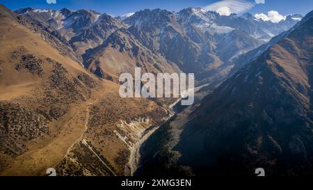 Das Luftbild des Bergtals im Ala-Archa-Nationalpark in Kirgisistan, mit dem Fluss, der durch malerische Berge mit herbstlichen Farben fließt. Stockfoto