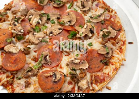 Eine Nahaufnahme der Beläge einer Milch- und glutenfreien frisch gebackenen Pizza auf einem Herd. Stockfoto