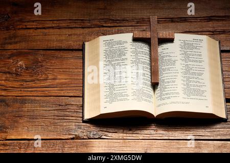 Bibel und Kreuz auf Holztisch, über dem Bild mit Platz für Text. Religion des Christentums Stockfoto