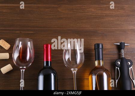 Flache Lagenkomposition mit Flügelkorkenzieher und Wein auf Holztisch. Leerzeichen für Text Stockfoto
