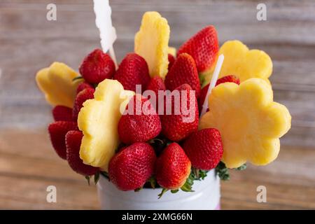 Blick auf ein Bouquet von essbarem frischem Obst mit Ananasblüten und Erdbeeren. Stockfoto