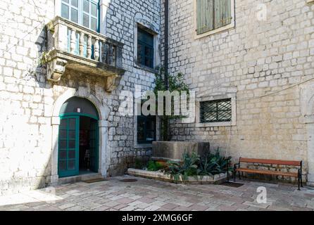 Kotor, Montenegro - 4. Oktober 2019: Ein malerisches Steingebäude mit grünen Akzenten in der historischen Stadt. Stockfoto