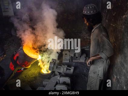 Bangladeschischer Mann, der geschmolzenen Stahl in eine Form in der Dhaka Werft, Dhaka Division, Keraniganj, Bangladesch Stockfoto