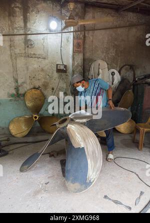 Dockyard-Arbeiter poliert einen Propeller, Dhaka Division, Keraniganj, Bangladesch Stockfoto