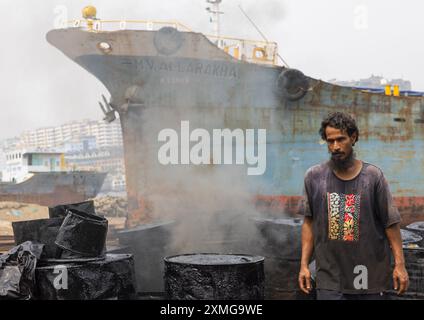 Bangladeschi Mann brennt Asphalt in der Dhaka Werft, Dhaka Division, Keraniganj, Bangladesch Stockfoto