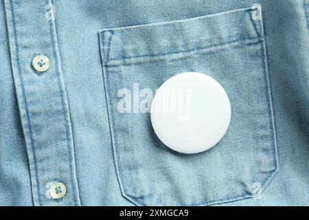 Weißes Knopfabzeichen auf dem Jeansshirt, Ansicht von oben. Modell für Design Stockfoto