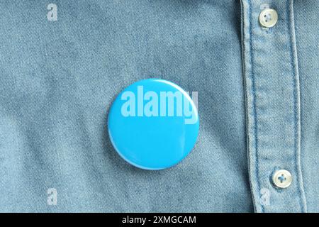 Blaues Knopfabzeichen auf dem Jeansshirt, Ansicht von oben. Modell für Design Stockfoto