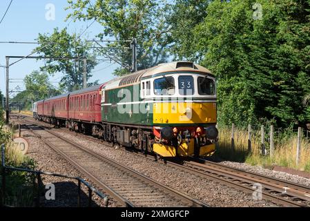 Ingatestone, Essex, Großbritannien. Juli 2024. Der Organisator UK Railtours betreibt einen klassischen dieselgeschleppten Personenzug vom Bahnhof London Fenchurch Street in die Küstenstadt Clacton-on-Sea in Essex, zunächst mit einer Lokomotive der British Rail Class 33 Nummer D6515 aus den 1960er Jahren bis nach Harwich. Eine Lokomotive der Baureihe 66 bringt den Zug nach Clacton und die Rückfahrt nach London. 98 dieselelektrische Lokomotiven der Baureihe 33 wurden zwischen 1960 und 1962 für die südliche Region der British Railways gebaut, die letzte wurde Mitte der 1990er Jahre ausgemustert Stockfoto